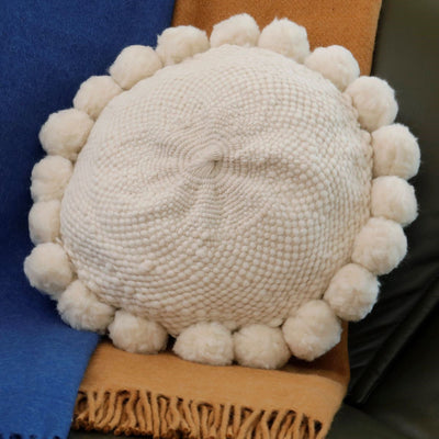 Cojín redondo de lana de oveja con pompones
